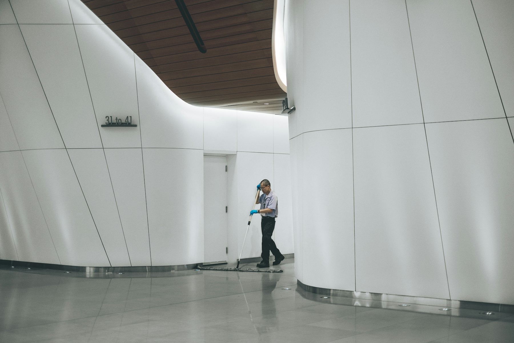 Agent d'entretien nettoyant un sol dans un hall